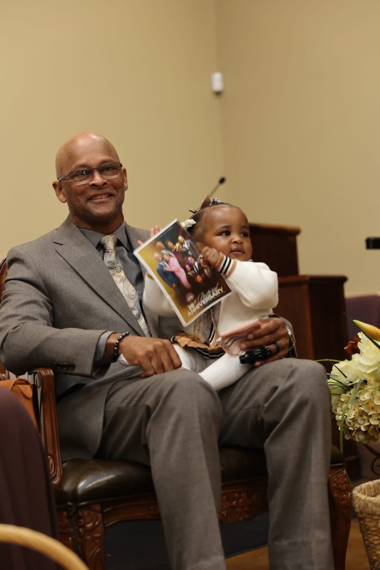 A Greater Grove Street member seated with a young child