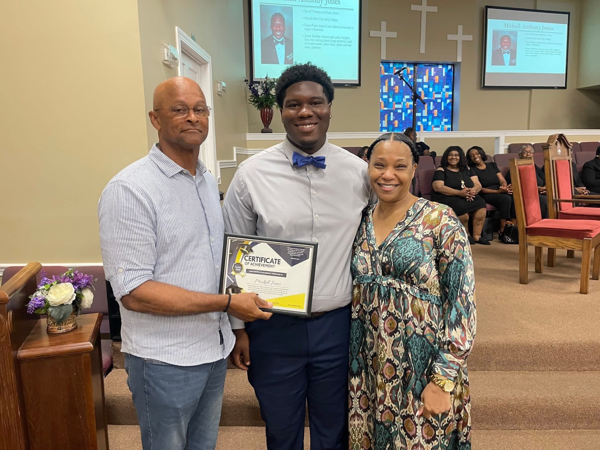 A young man receiving a certificate of achievement at Greater Grove Street