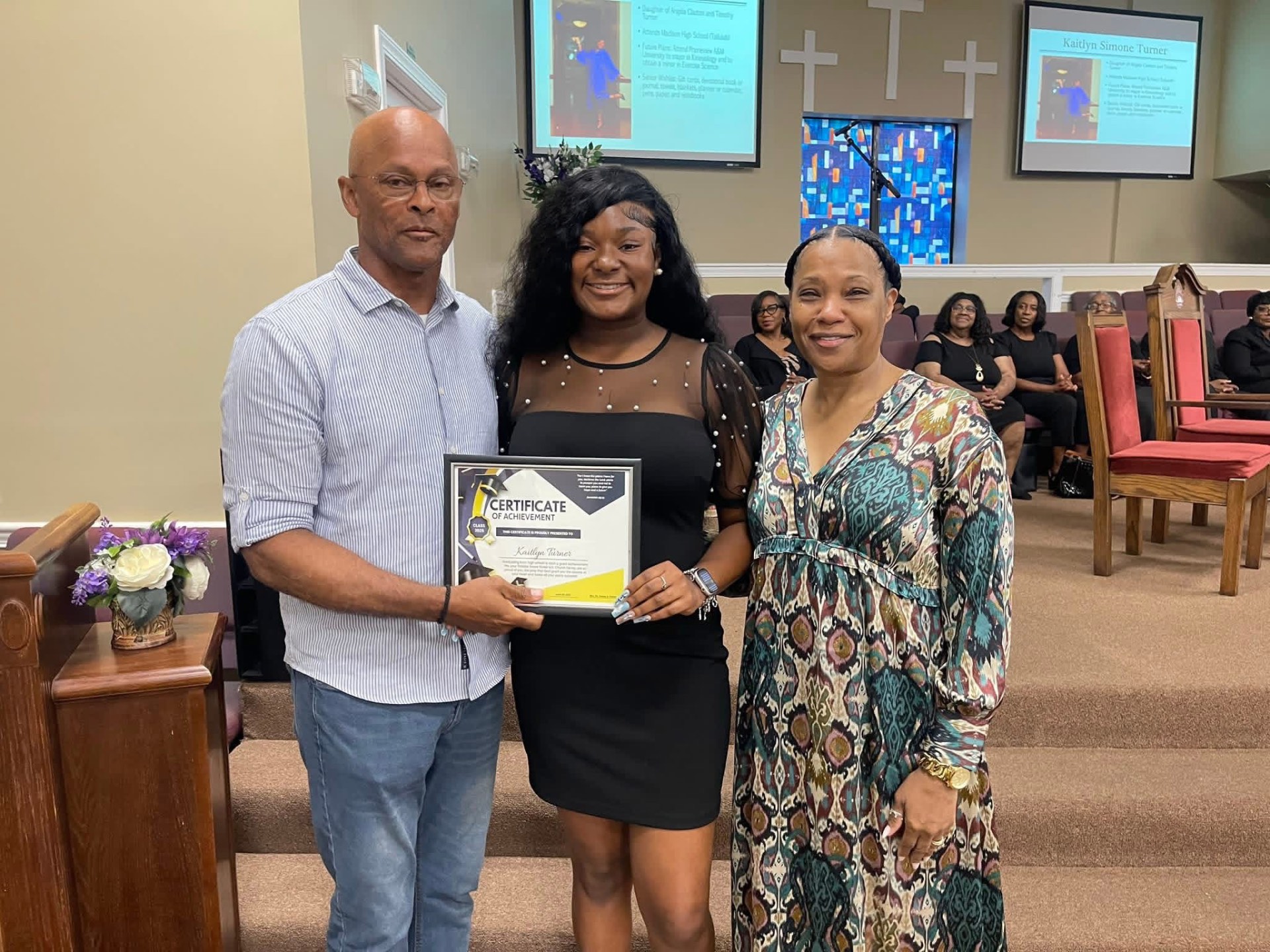 A young woman receiving a certificate of achievement at Greater Grove Street
